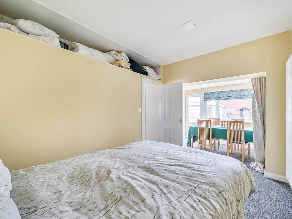 A bedroom with a bed and a doorway leading to a dining area at Cottage Sleeps 6 with Parking and Garden in Bridlington