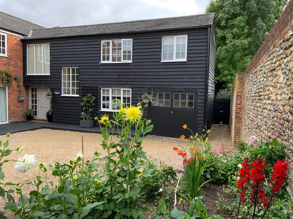 A building with a front door and windows surrounded by a flower bed at a residential property