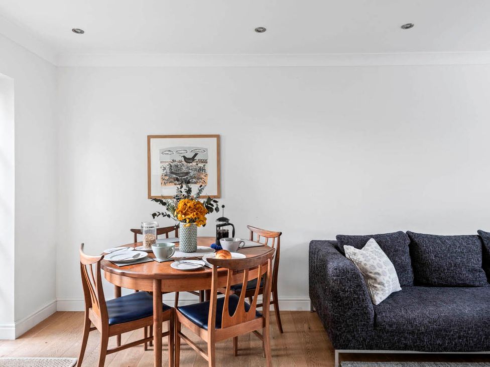 A dining room with a round table and a sofa at the property in location