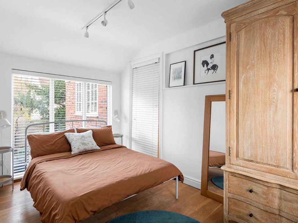 A bedroom featuring a bed, wardrobe, mirror, and lamp at the property in 