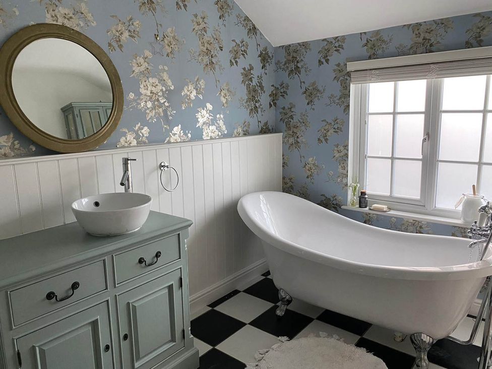 A bathroom with a bathtub and sink at The Old Barn in Manchester
