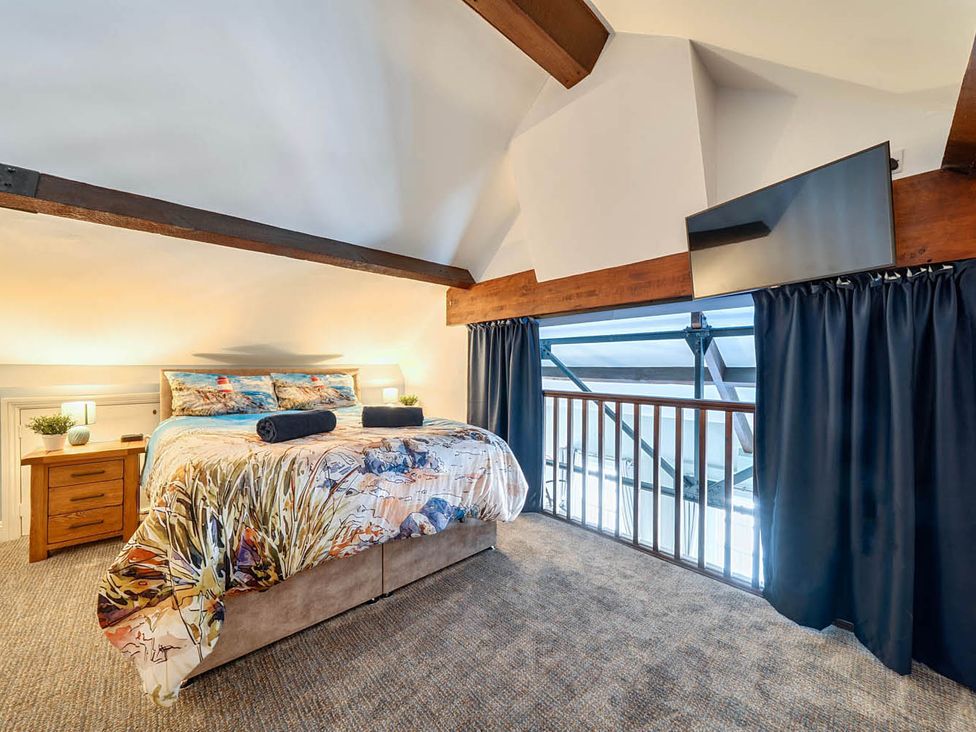 A bedroom with a bed and television at 4 Bed Sleeps 8 Pool Table Sea View Parking in Swanage