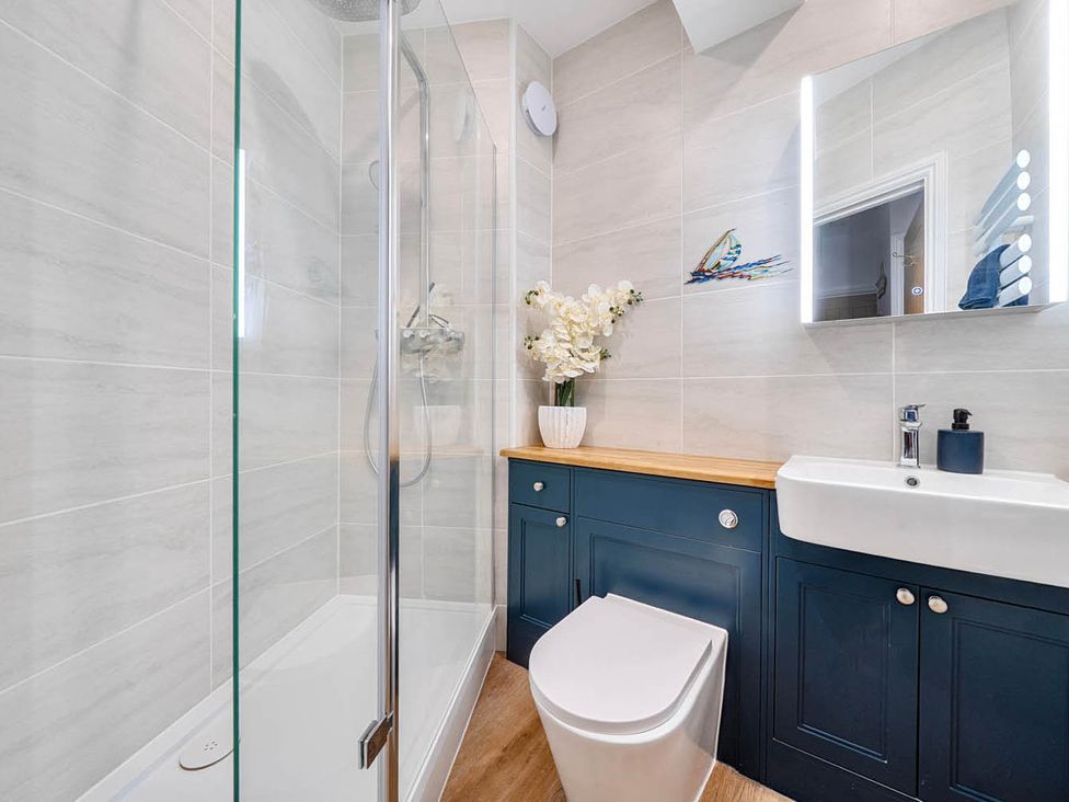 A bathroom with shower, toilet, sink and vanity unit at 4 Bed Sleeps 8 Pool Table Sea View Parking in Swanage