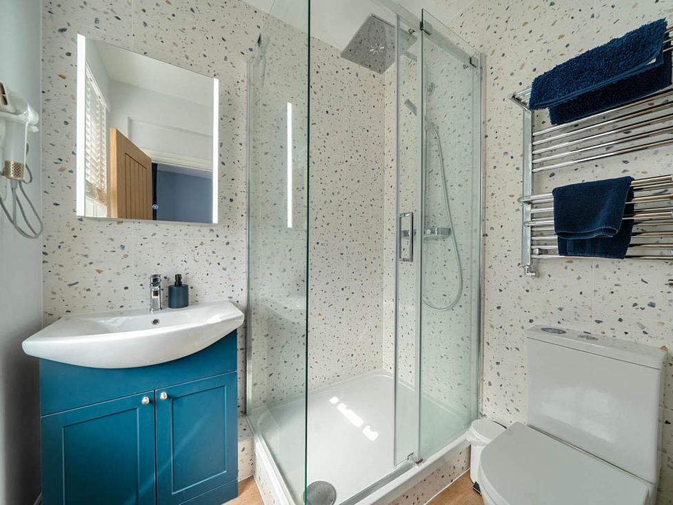 A bathroom with a shower, sink, and toilet at 4 Bed Sleeps 8 Pool Table Sea View Parking Swanage