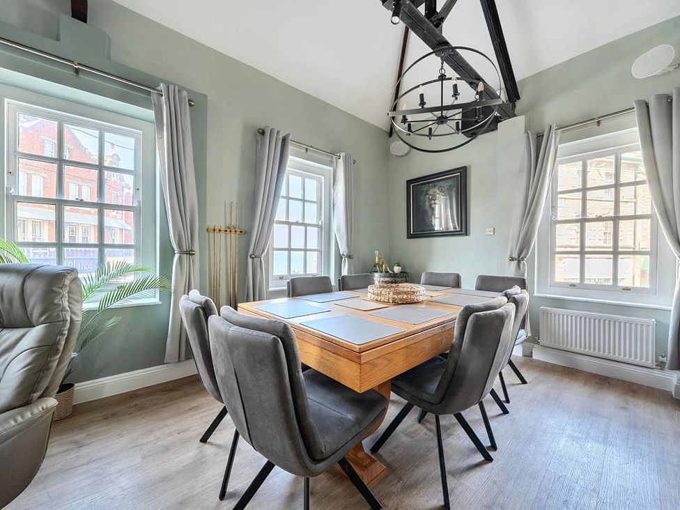 A dining room with a table and chairs at 4 Bed Sleeps 8 Pool Table Sea View Parking in Swanage
