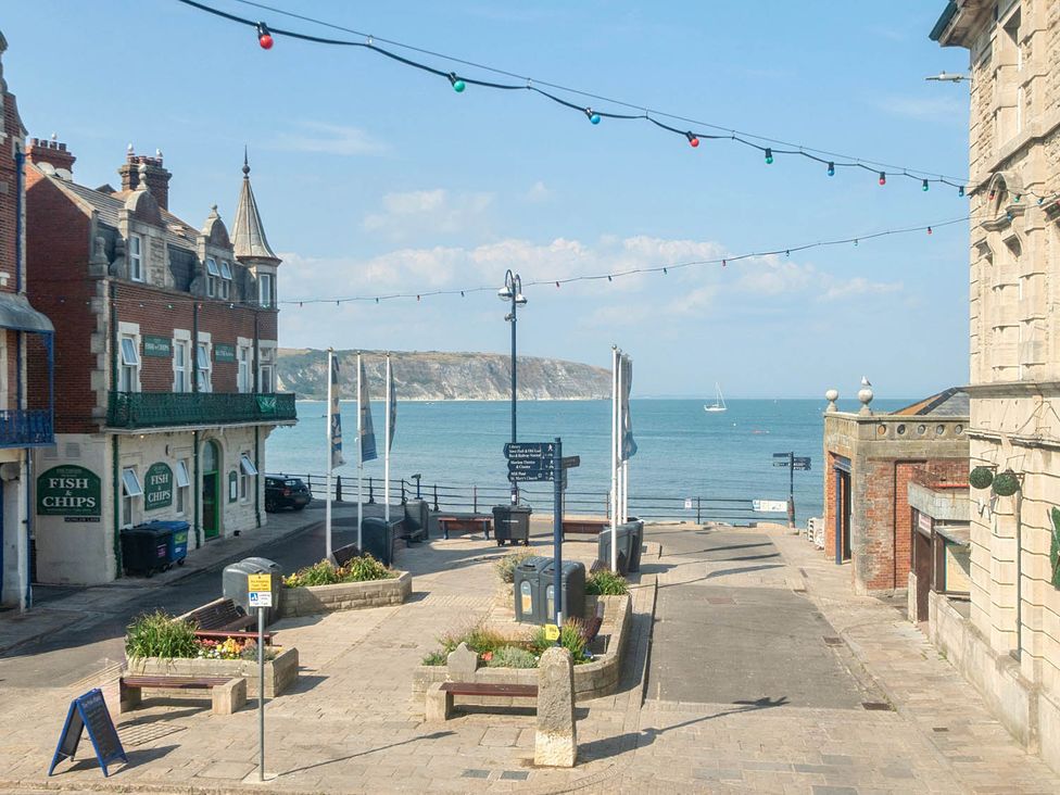 A view of a street with shops and the ocean in Swanage