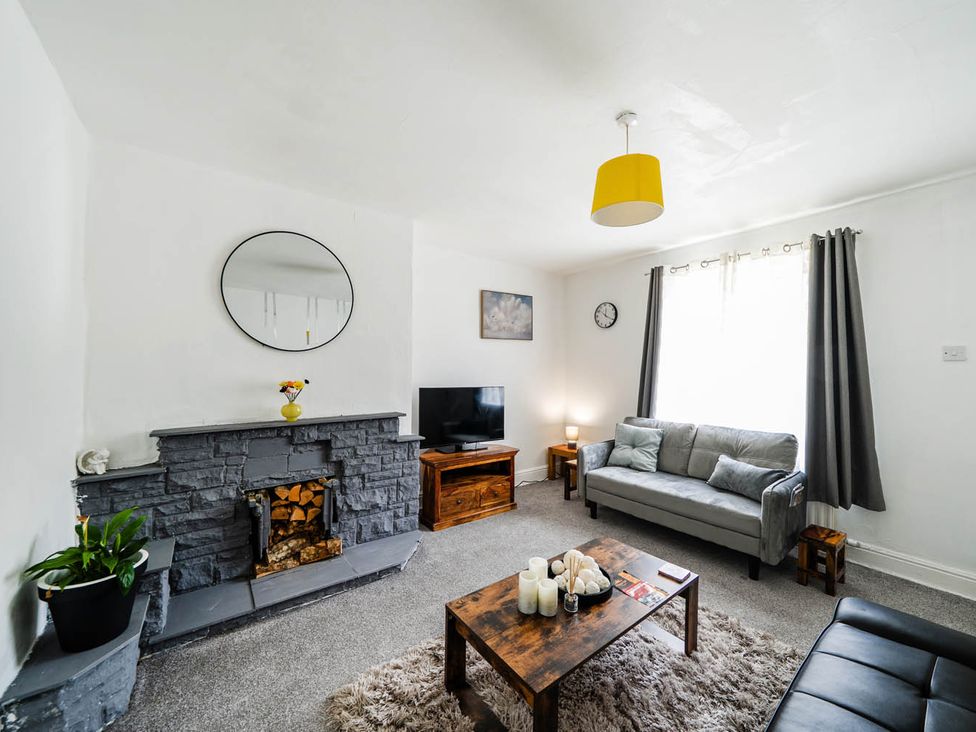 A living room with a fireplace and sofa at The Old Barn in Manchester
