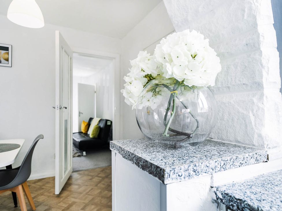 A living room with a flower vase on a granite surface at the property in unspecified location