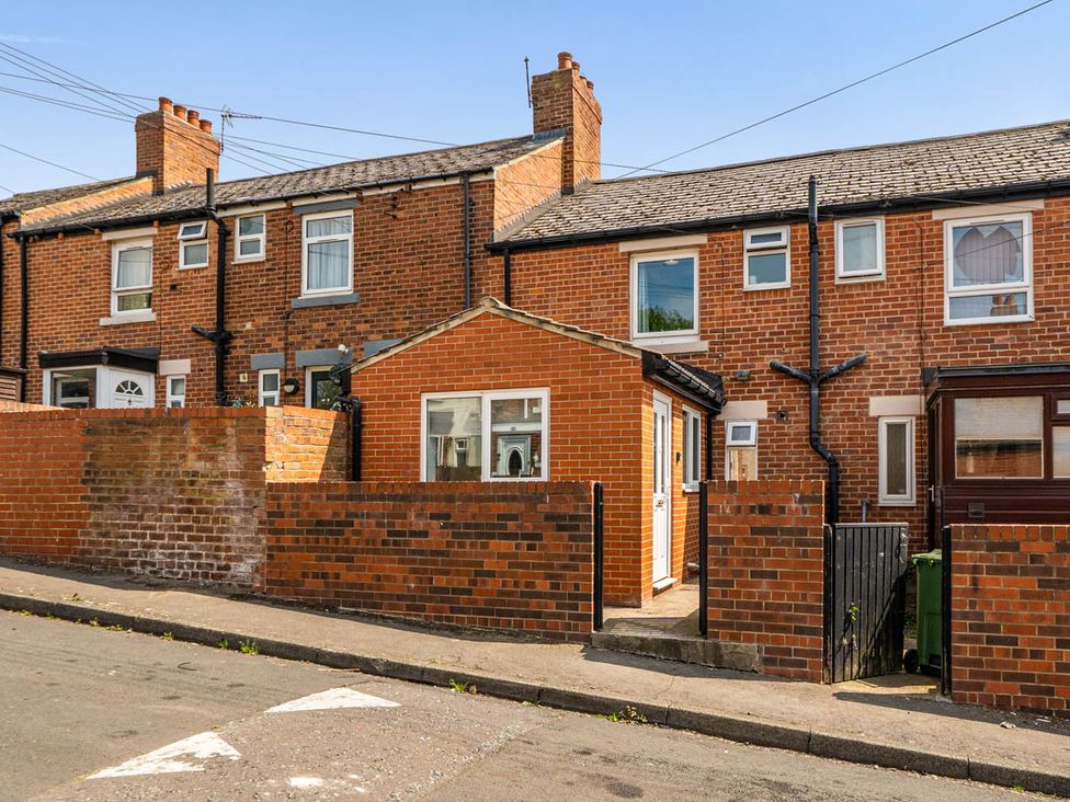 A brick house with a fence and street in the front at 