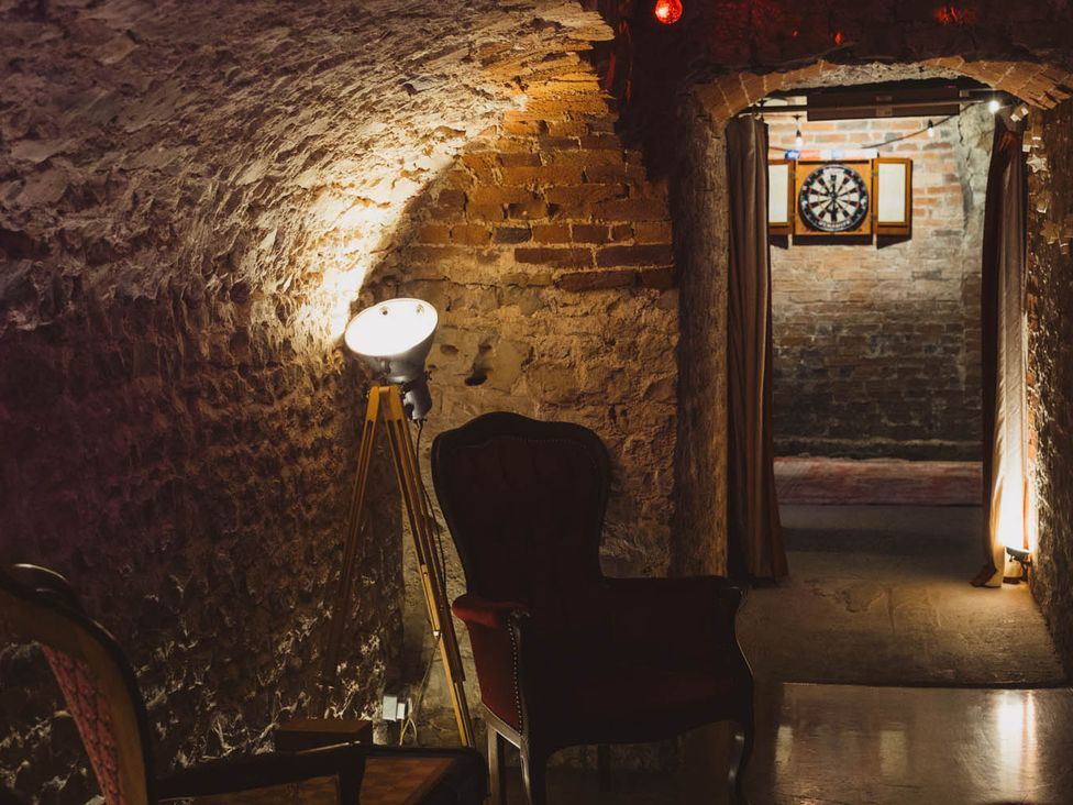 A game room with a dartboard and a chair at a property