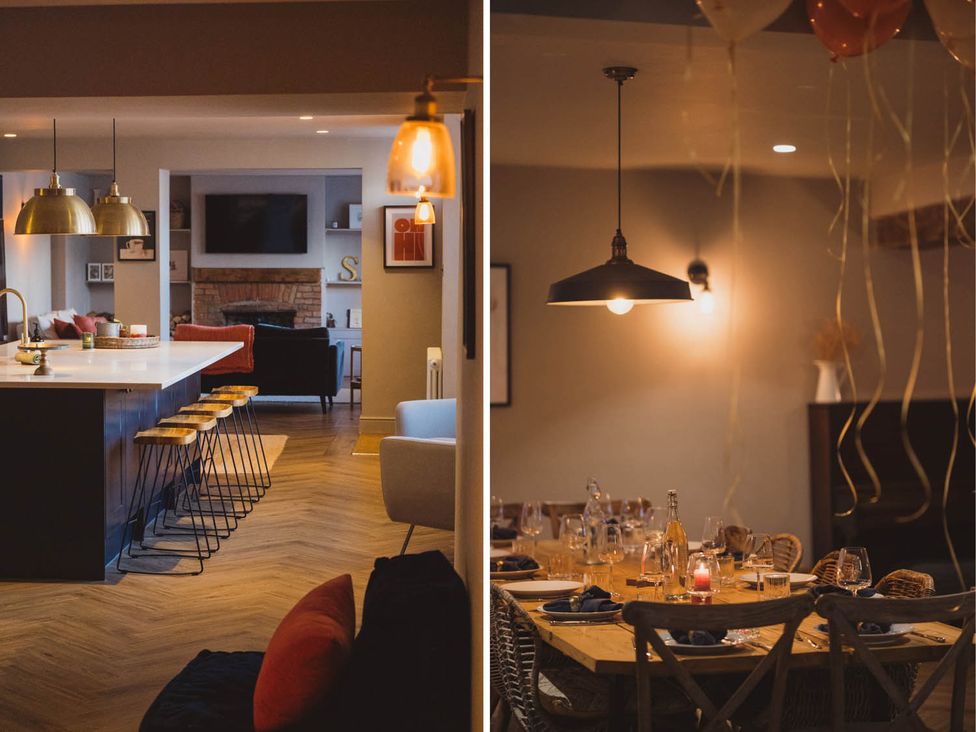 A kitchen with an island and stools alongside a dining area table at The Old Barn in Manchester
