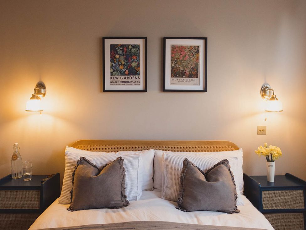 A bedroom with a bed and framed art at The Old Barn in Manchester