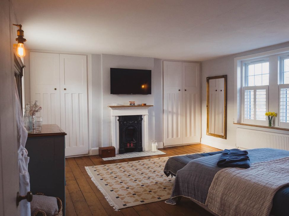 A bedroom with a bed and a fireplace at The Old Barn in Manchester