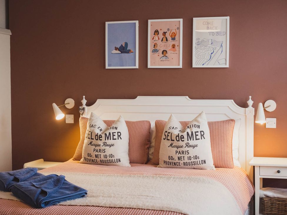 A bedroom with a bed, pillows, and wall art at the property
