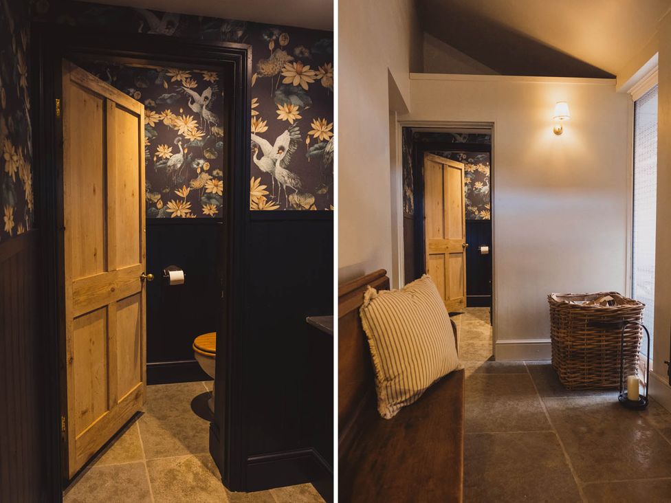 A bathroom with toilet and floral wallpaper at The Old Barn in Manchester