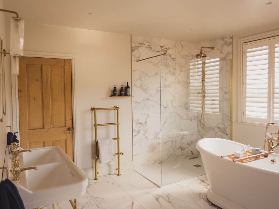 A bathroom featuring a bathtub, shower, sink and towel rack at The Old Barn in Manchester