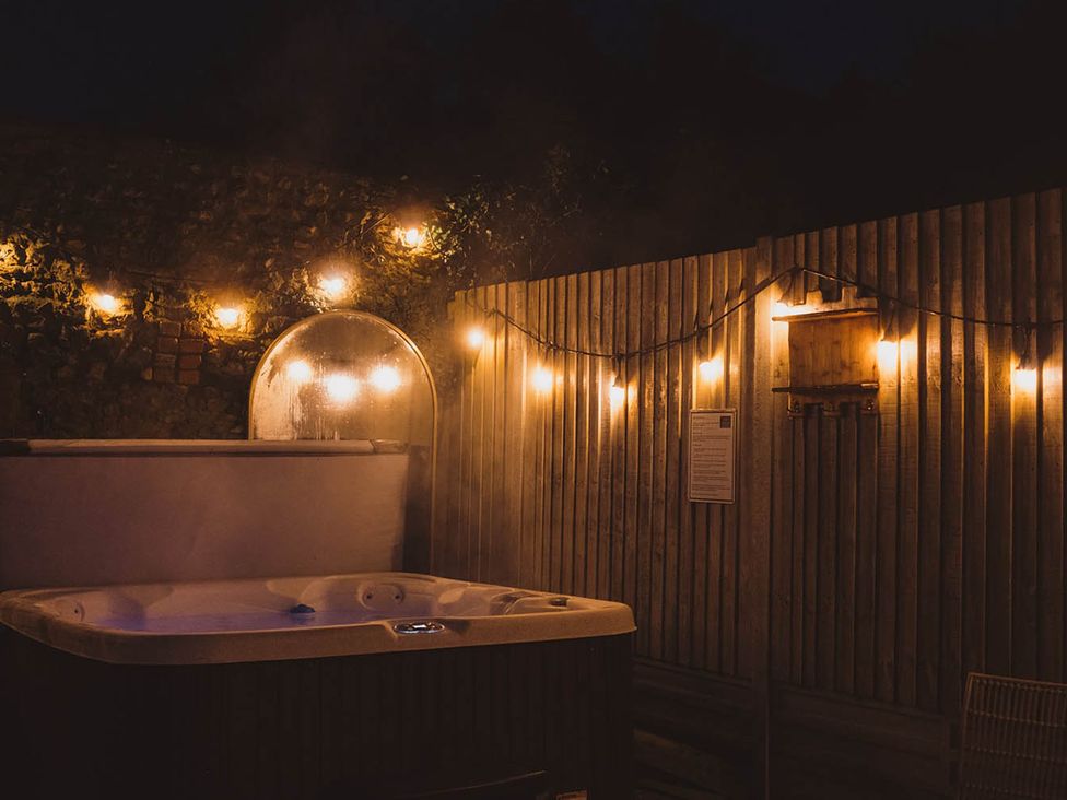 A hot tub with string lights at an outdoor space