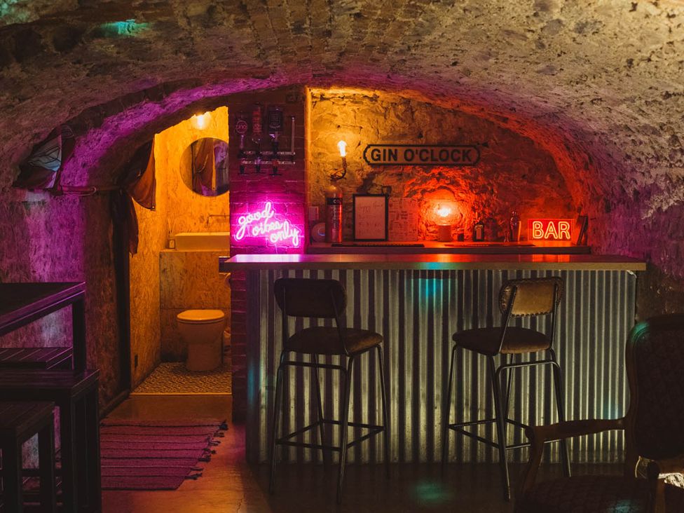 A bar area with stools and restroom at The Old Barn in Manchester
