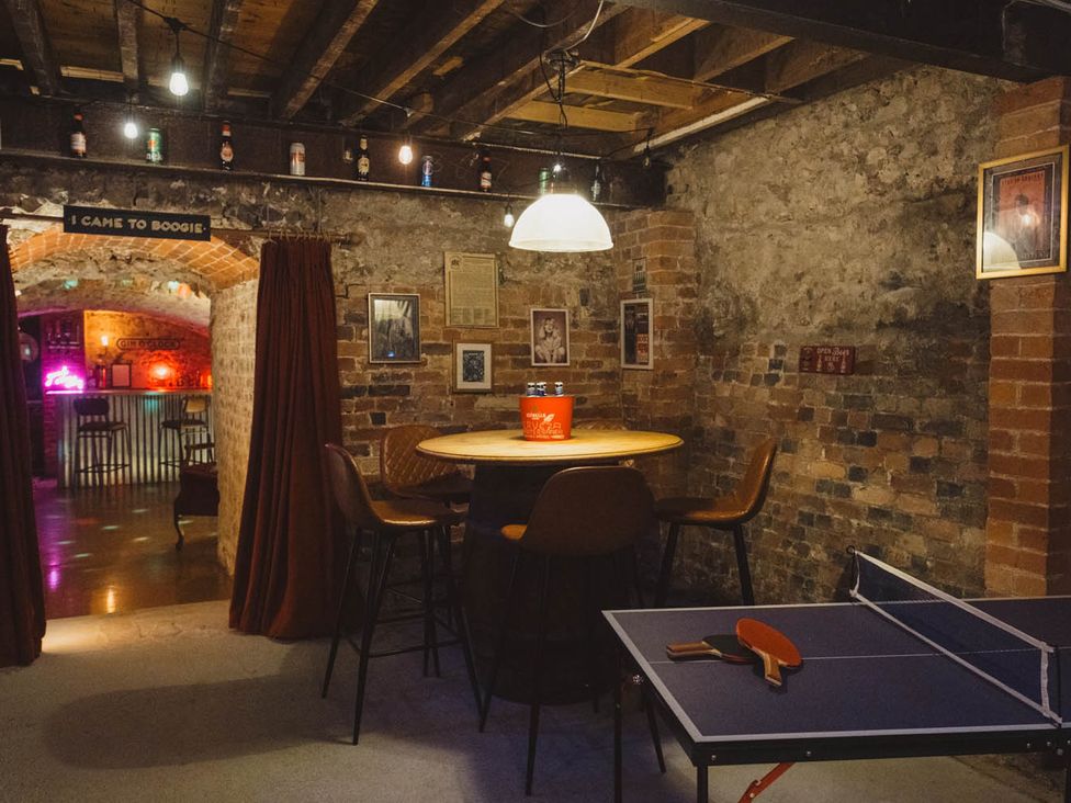 A basement with a ping pong table and seating area at 