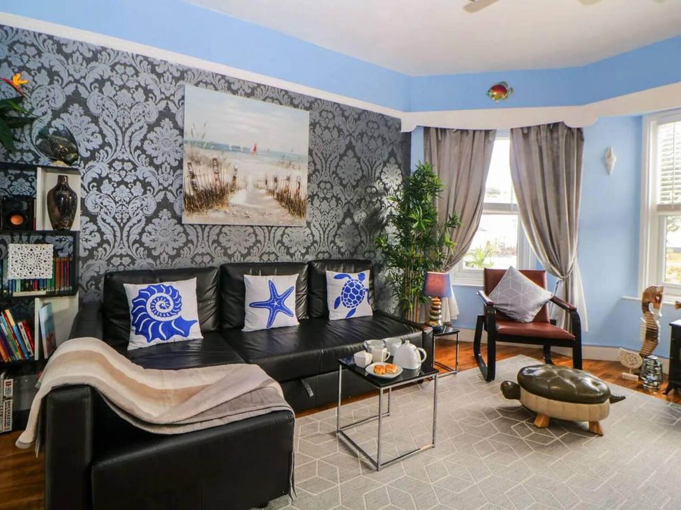 A living room with a couch, table, and bookshelf at the property