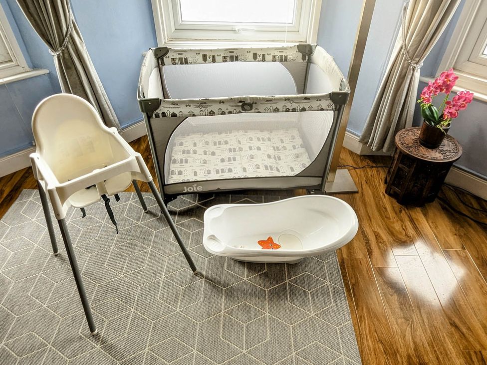 A crib, high chair, and baby bath in a nursery at 