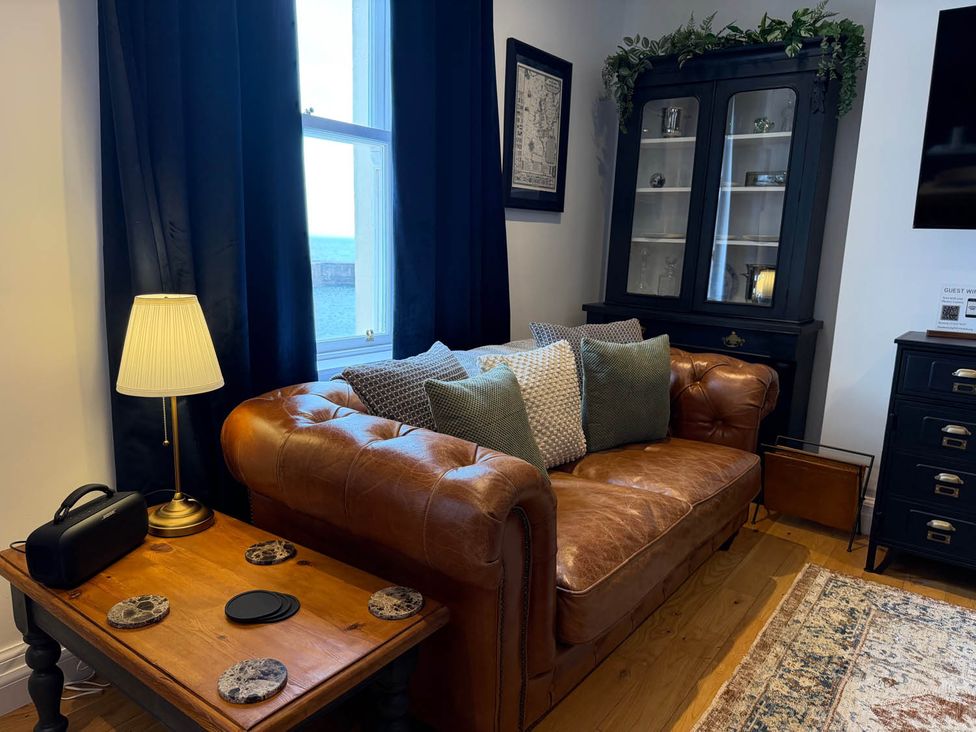 A living room with a leather sofa and lamp at a property in an unspecified location