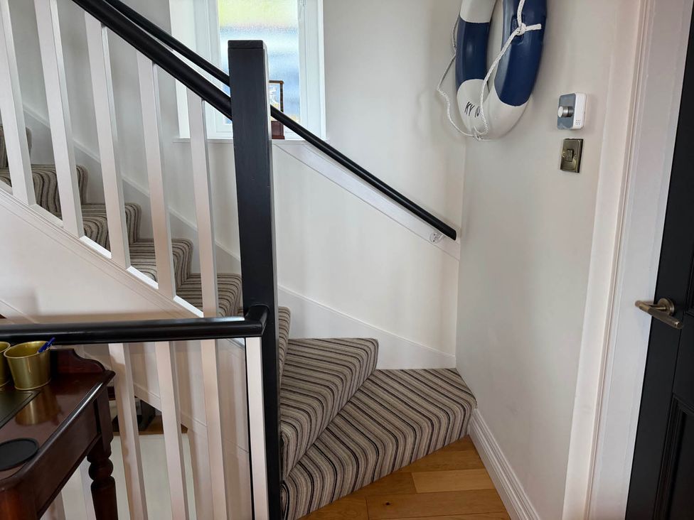 A staircase with handrail and striped carpet at the property in the location