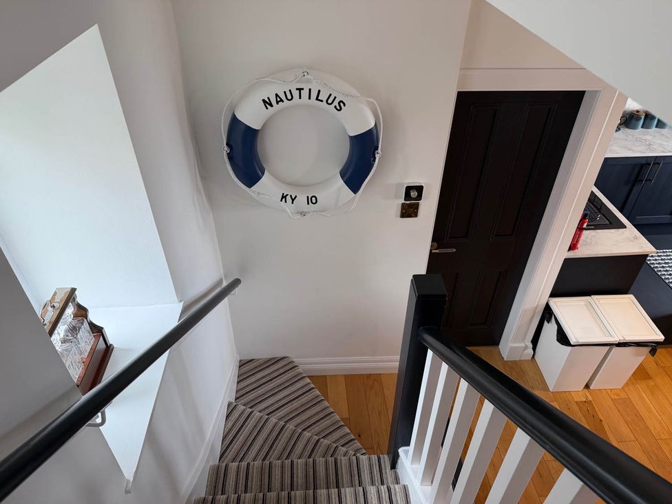 A staircase with a life buoy on the wall at a property