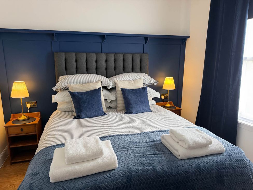 A bedroom with a bed and bedside tables at 