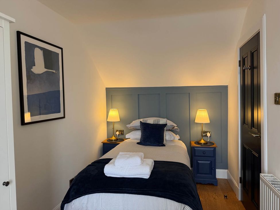 A bedroom with a single bed and lamp at The Old Barn in Manchester