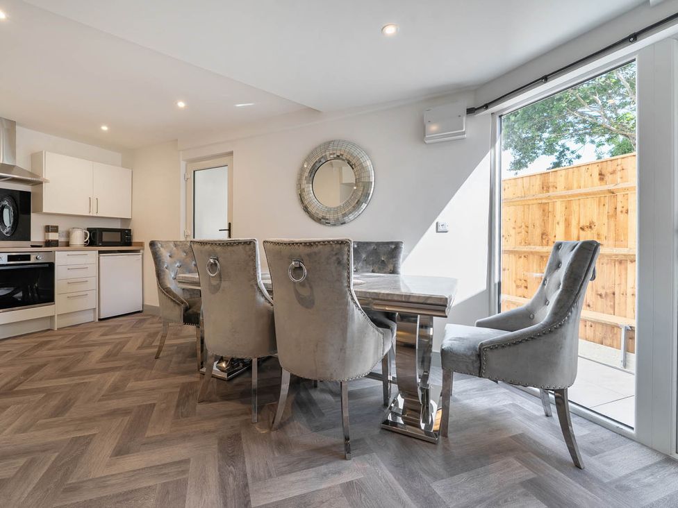 A dining room with a table and chairs at Annexe Bungalow Sleeps 2 Maximum Parking Garden in Scratby