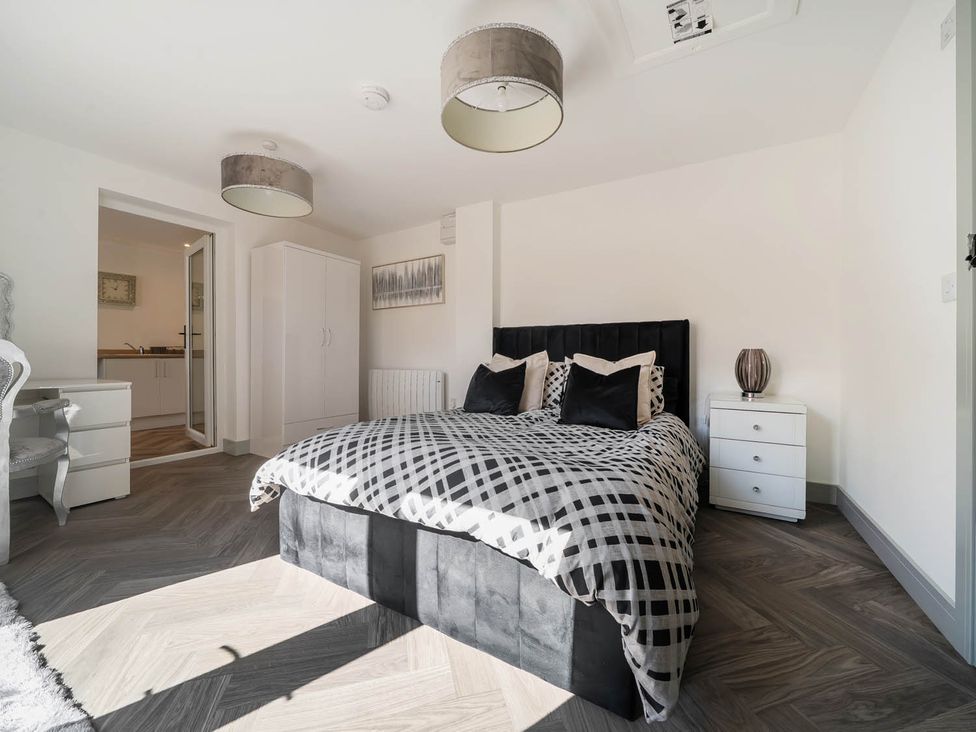 A bedroom with a bed and bedside table at Annexe Bungalow Sleeps 2 Maximum Parking Garden Scratby