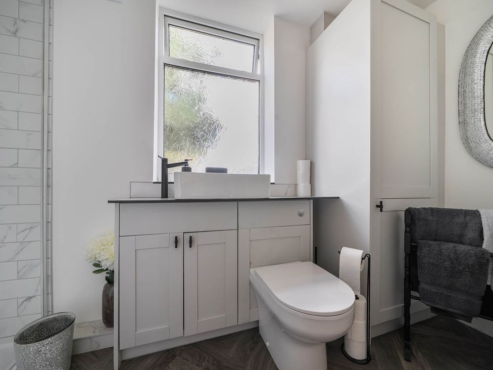 A bathroom with a sink, toilet, and cabinet at Annexe Bungalow Sleeps 2 Maximum Parking Garden Scratby