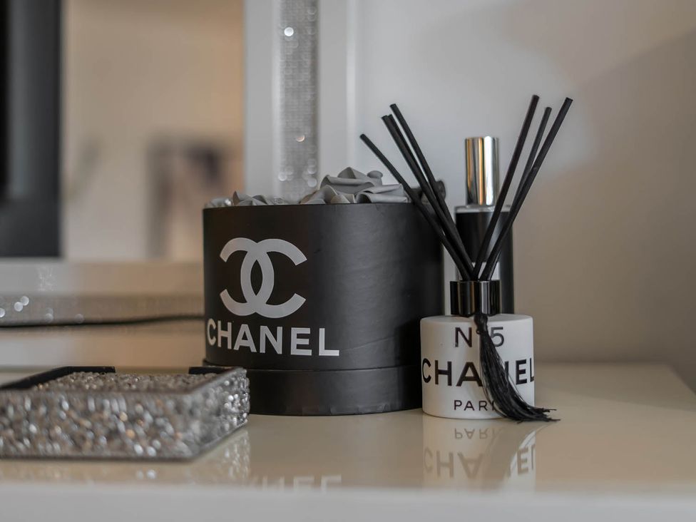 Decorative items including a Chanel box and reed diffuser at Annexe Bungalow Sleeps 2 Maximum Parking Garden Scratby