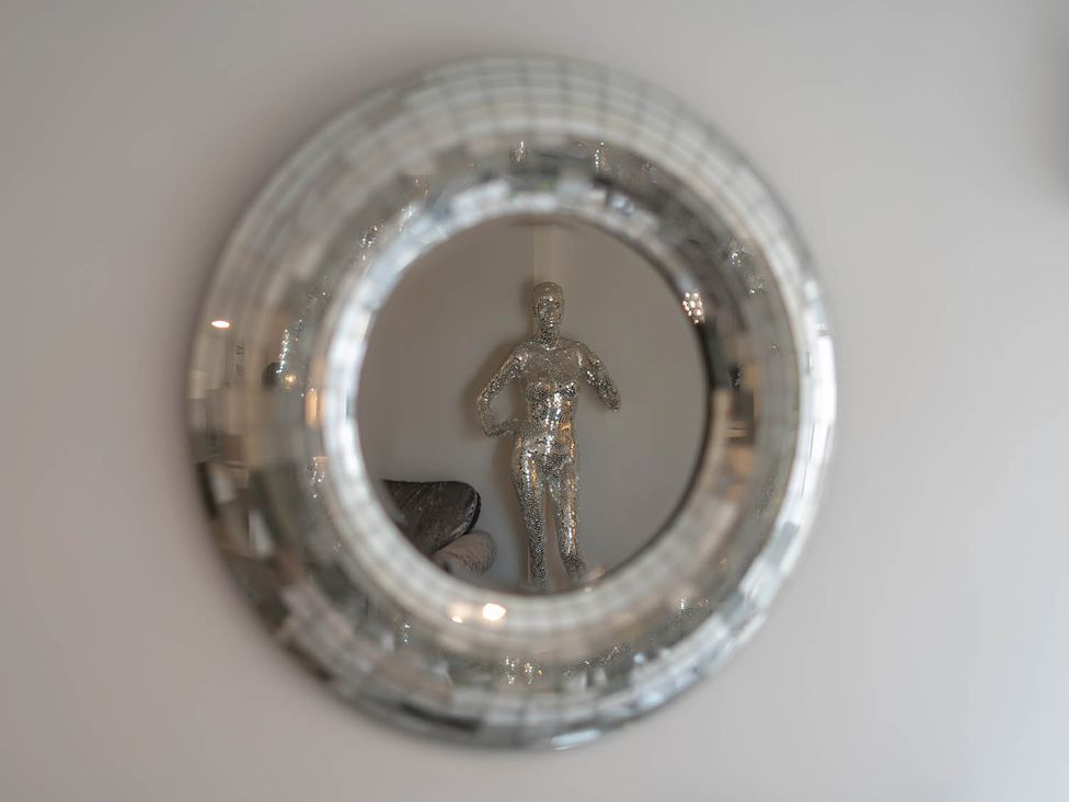 A decorative statue seen in a mirror at Annexe Bungalow Sleeps 2 Maximum Parking Garden in Scratby