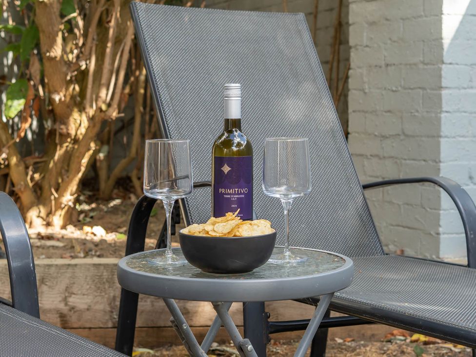 An outdoor seating area with wine and snacks at Annexe Bungalow Sleeps 2 Maximum Parking Garden in Scratby
