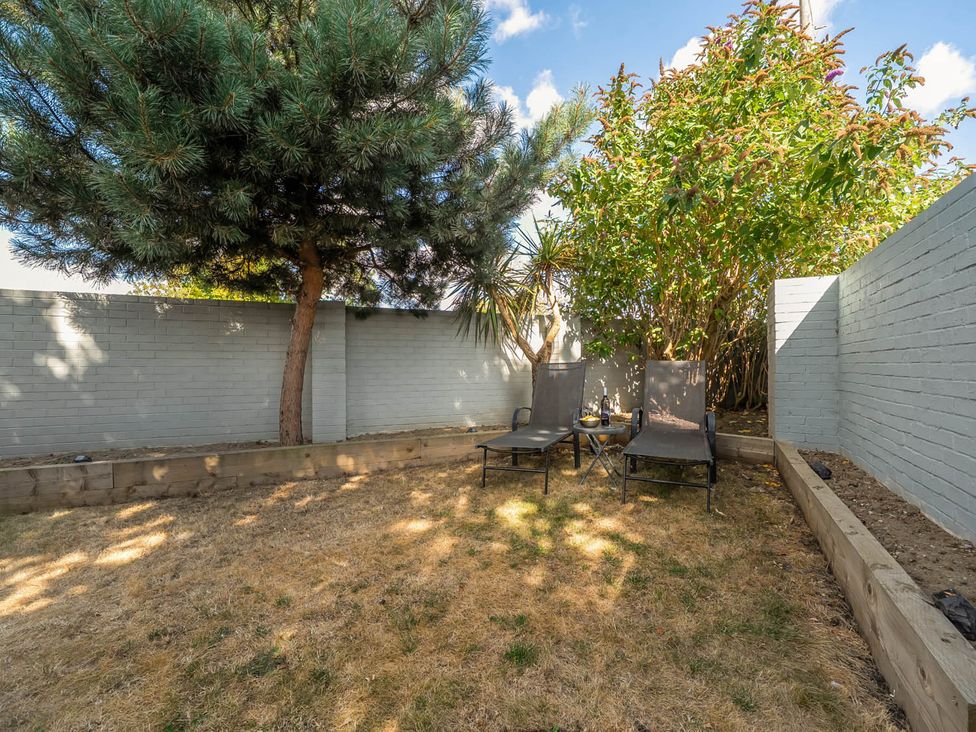 A garden with chairs and a table at Annexe Bungalow Sleeps 2 Maximum Parking Garden Scratby
