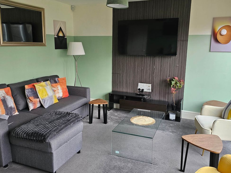 A living room with a TV and coffee table at House Sleeps 8 with WiFi in Corby