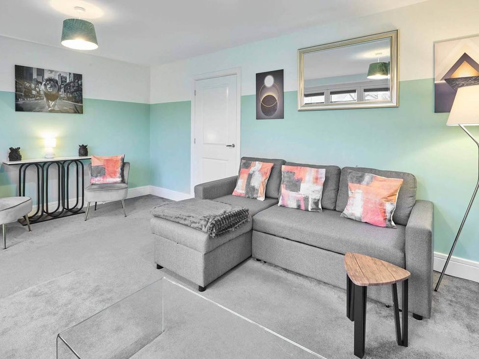 A living room with a sofa and armchair at House Sleeps 8 with WiFi in Corby