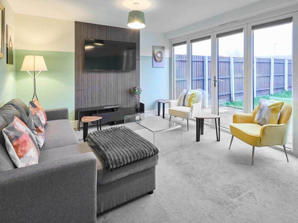 A living room with a sofa and armchairs at House Sleeps 8 with WiFi Corby