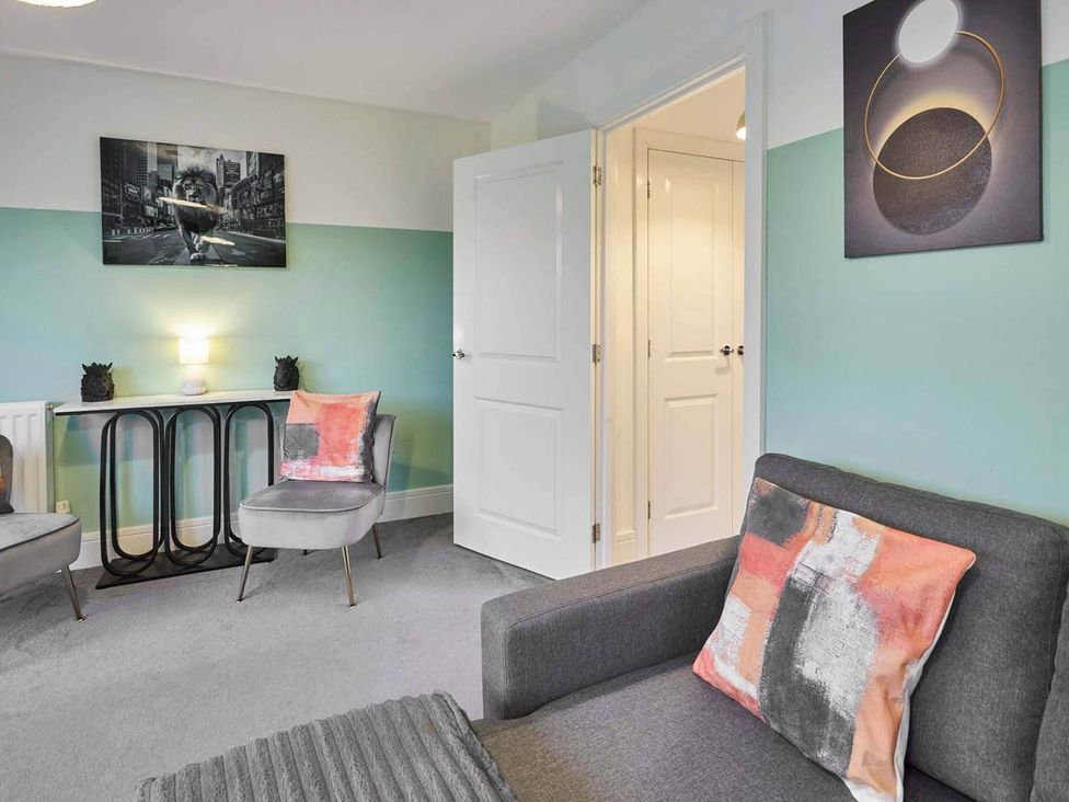 A living room with a sofa and armchairs at House Sleeps 8 with WiFi, Corby