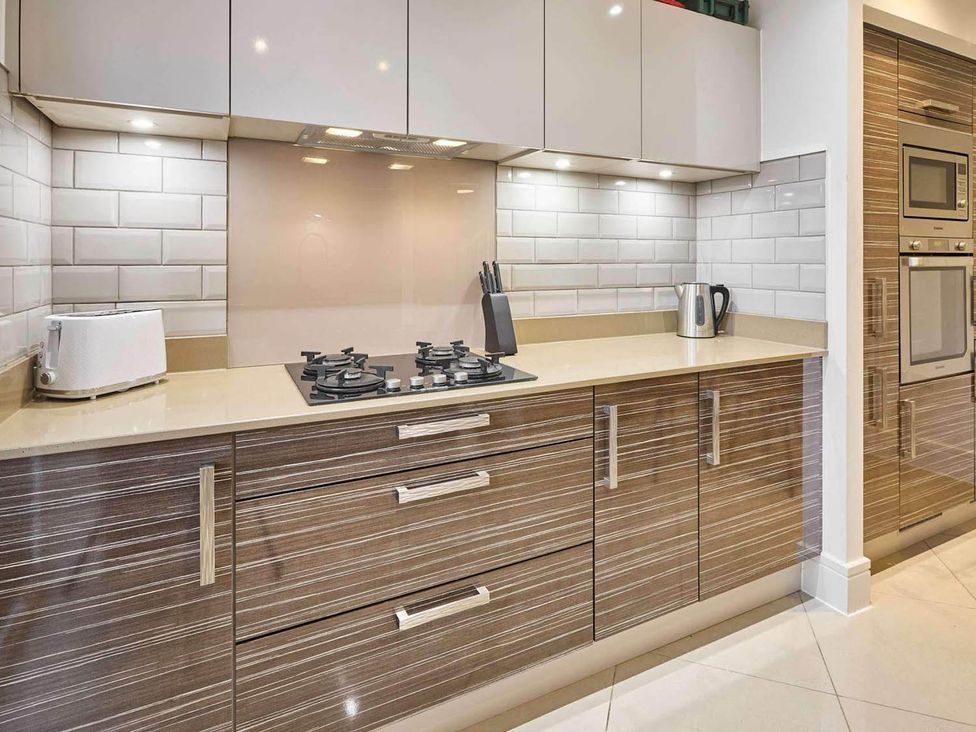 A kitchen with cabinets and a gas stove at House Sleeps 8 with WiFi Corby
