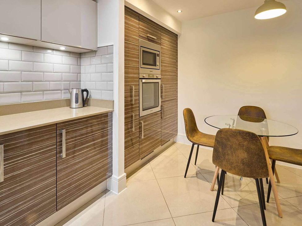 A kitchen with cabinets and dining area at House Sleeps 8 with WiFi Corby