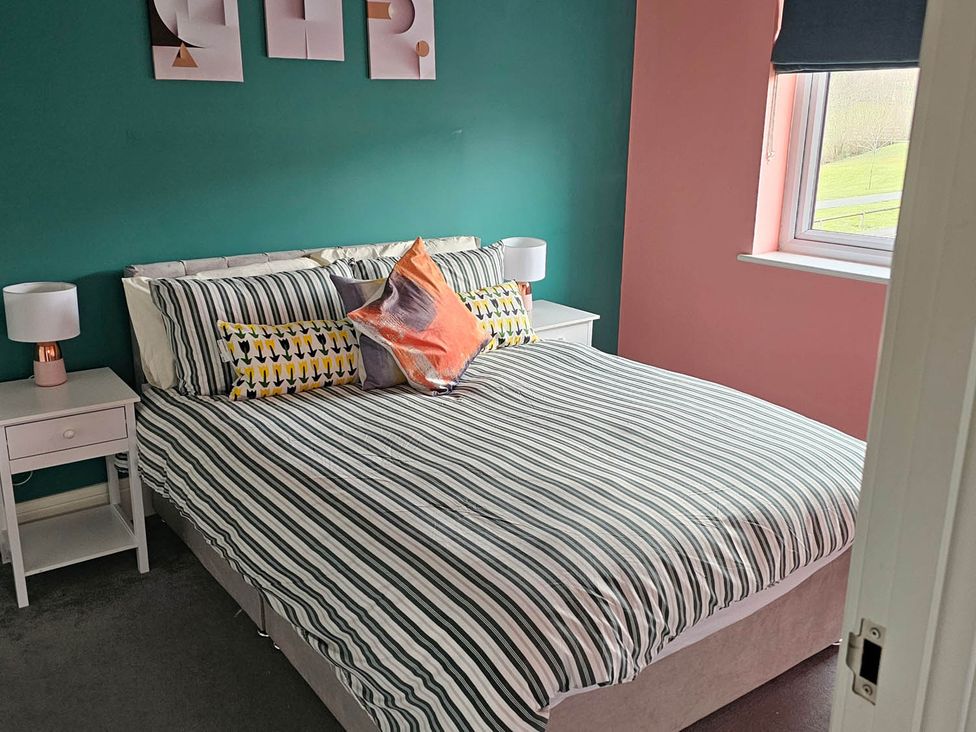 A bedroom with a bed and bedside tables at House Sleeps 8 with WiFi, Corby