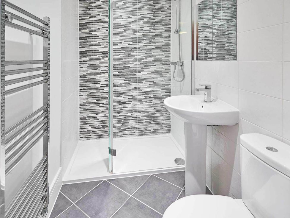 A bathroom with a shower, sink and toilet at House Sleeps 8 with WiFi, Corby