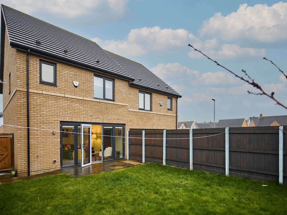 A house with a garden and fence at House Sleeps 8 with WiFi Corby