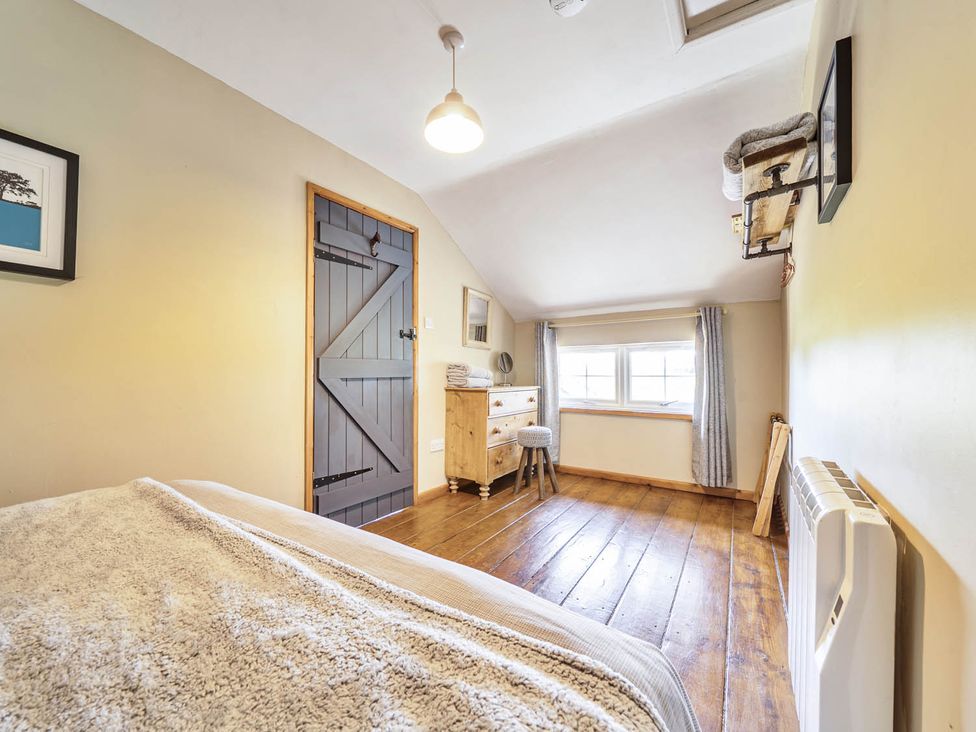A bedroom with a bed and a dresser at Hayloft Sleeps 3 with Enclosed terrace Dereham
