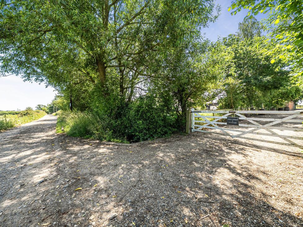 A pathway with a gate surrounded by trees and bushes at Hayloft Sleeps 3 with Enclosed terrace in Dereham