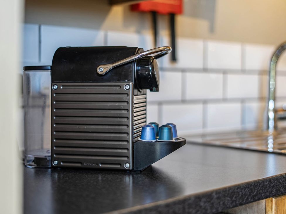 A coffee machine with capsules on a countertop at Hayloft Sleeps 3 with Enclosed terrace Dereham