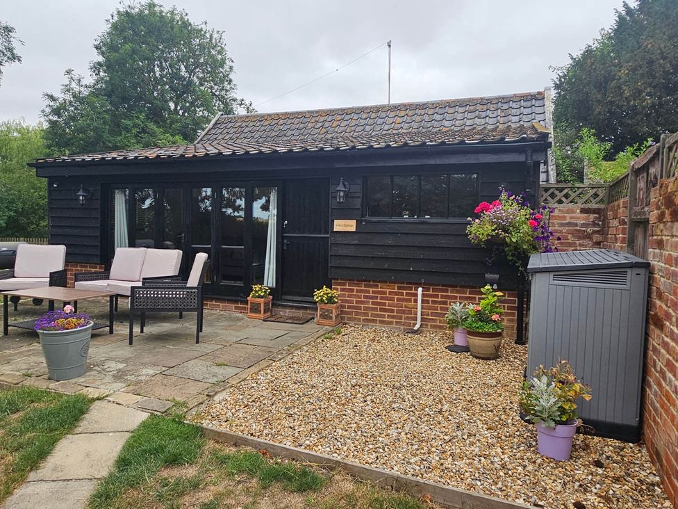 An outdoor patio area with a table and seating at Lily's Cottage Suffolk Sleeps 2 with Pets Mendlesham Green near Stowmarket